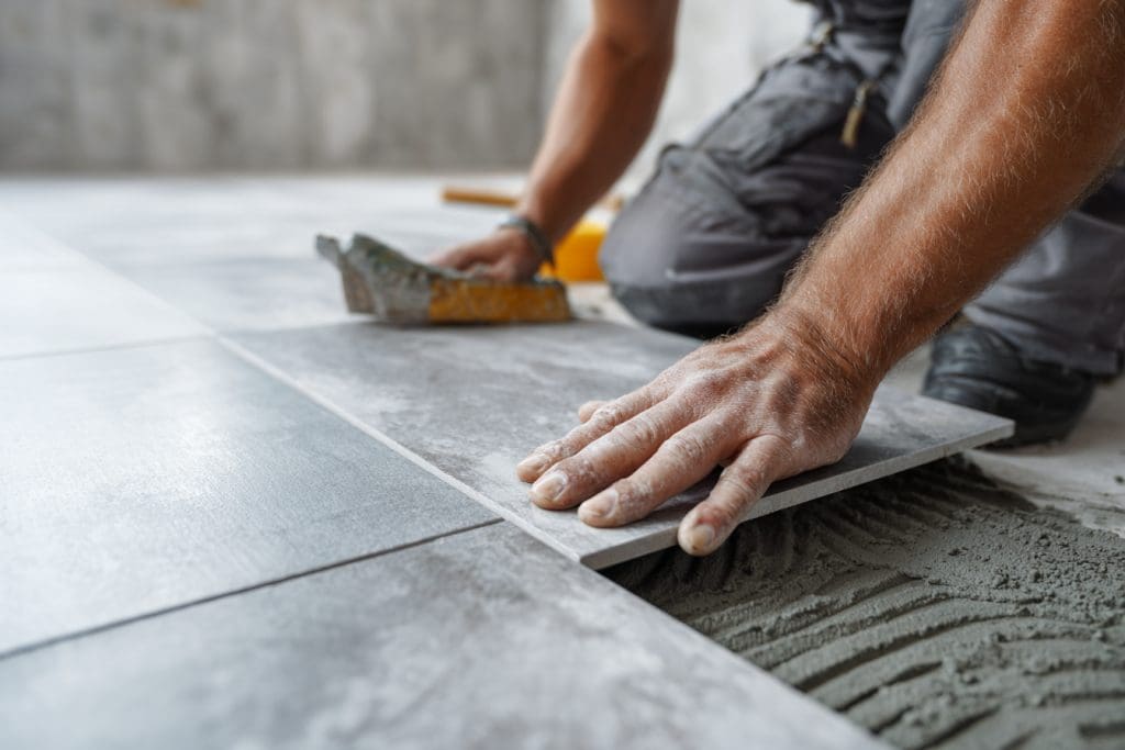 فني يقوم بتركيب بلاط بورسلان كبير الحجم